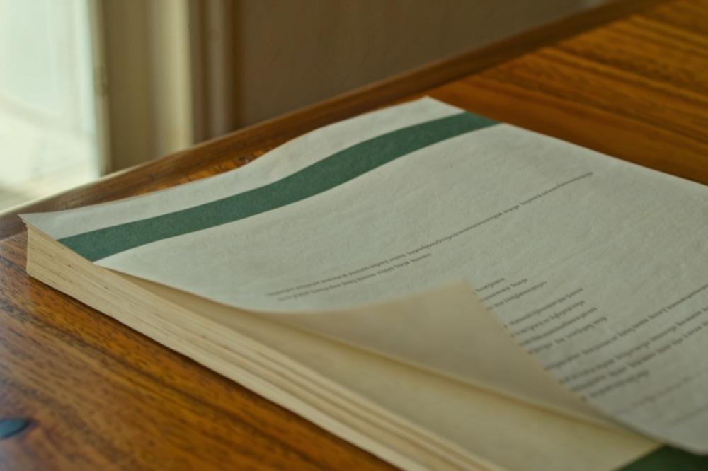 A bound valuation report with a deep green cover band on an oak desk